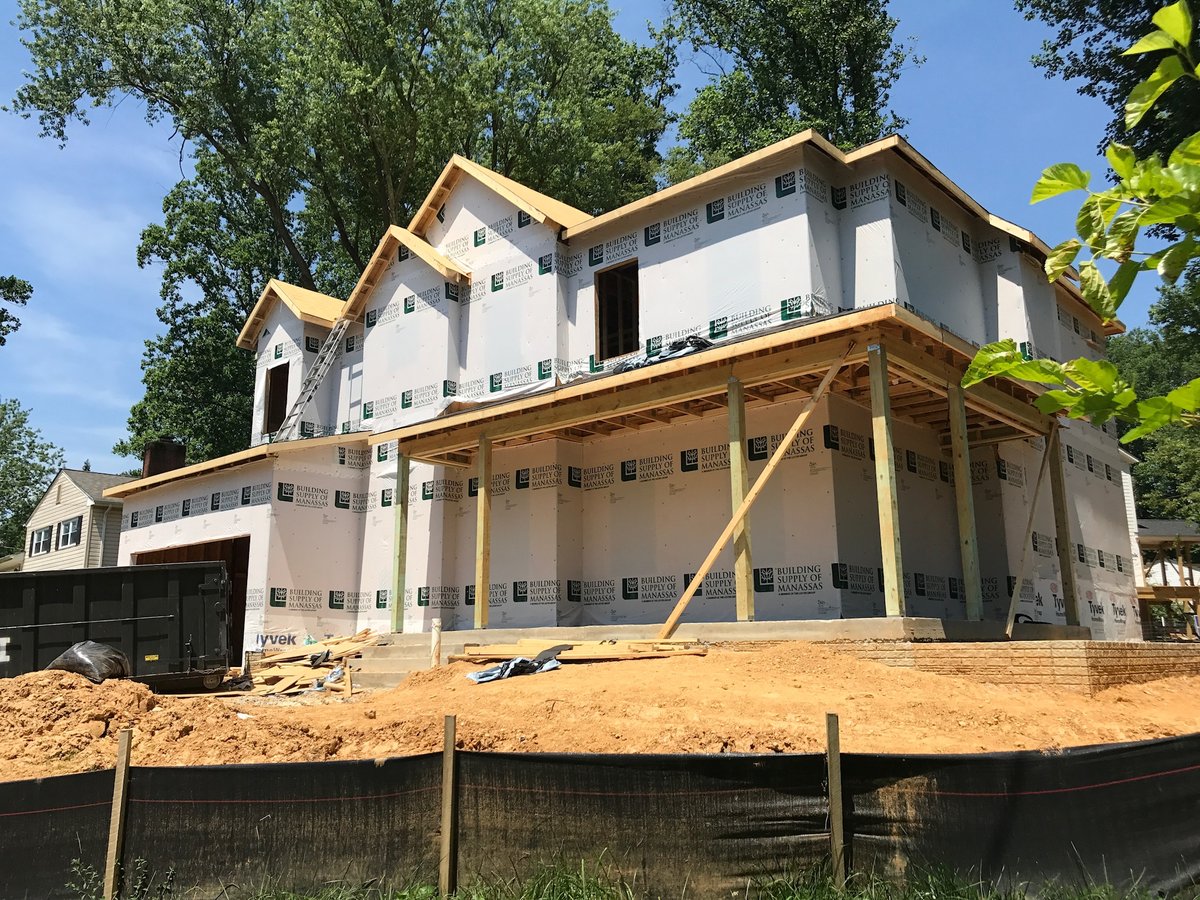 Home under construction with house wrap and framing before exterior renovation