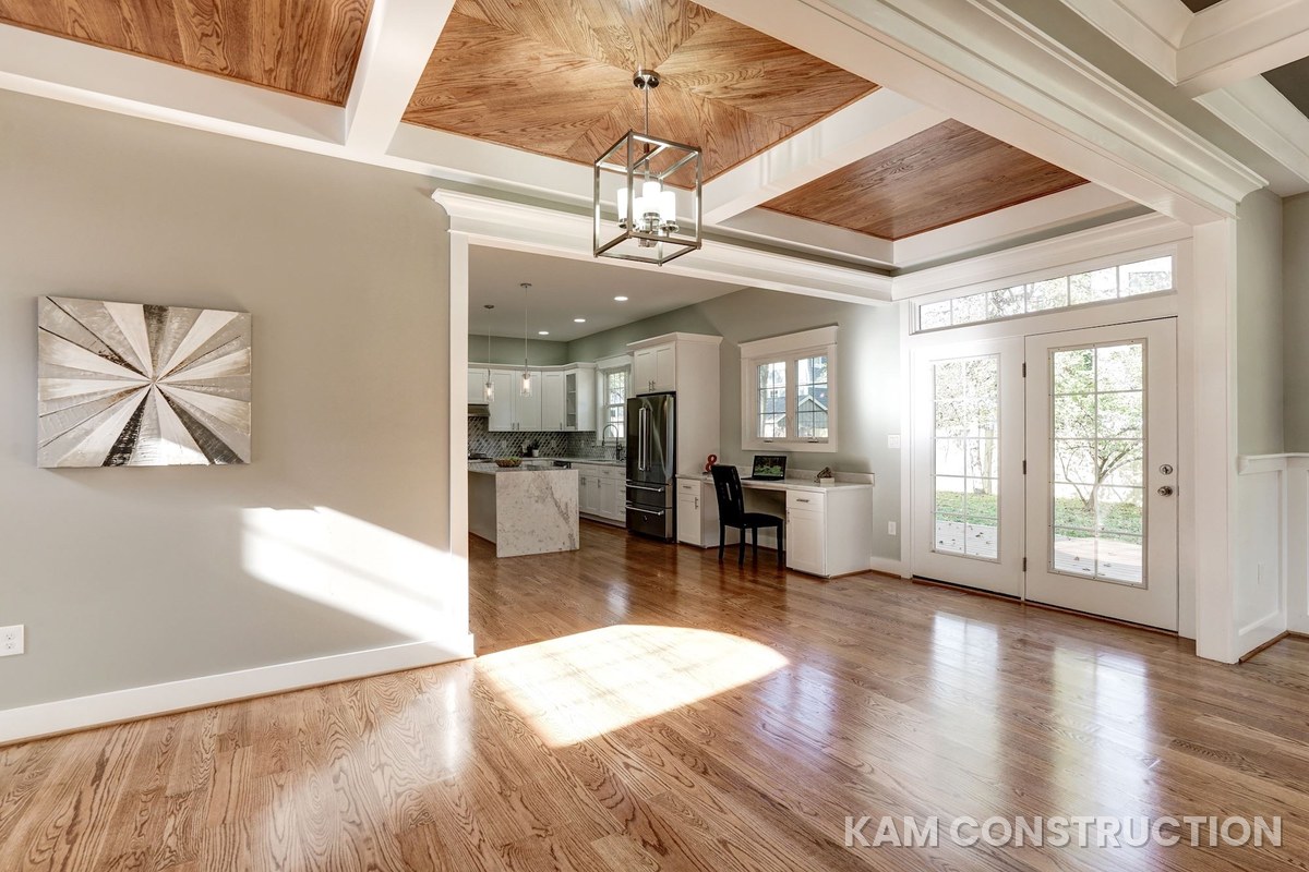 Breakfast area with wood-panel coffered ceiling opening to kitchen